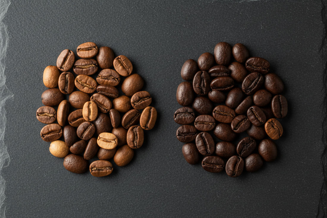 Two groups of coffee beans on a slate surface comparing specialty and commercial roast levels