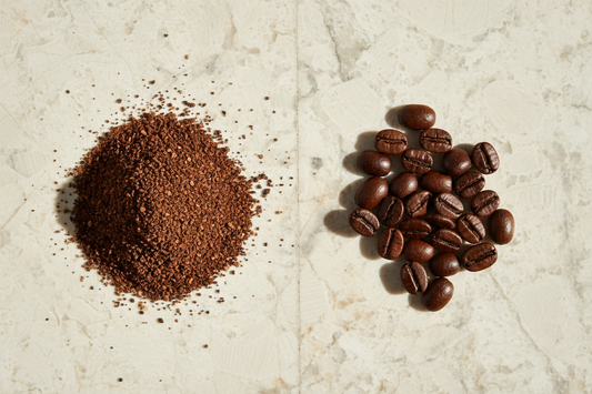 Side-by-side comparison of pre-ground coffee and whole bean coffee on a light stone surface in natural daylight